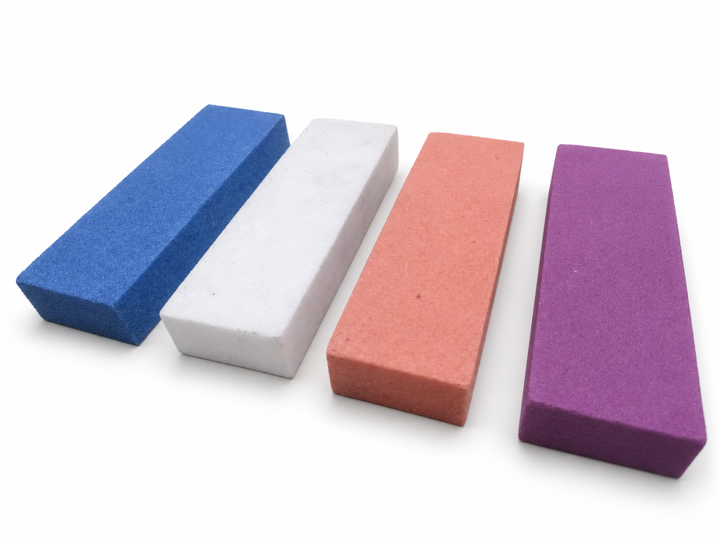 Coloured rectangular oil stones on a white studio background
